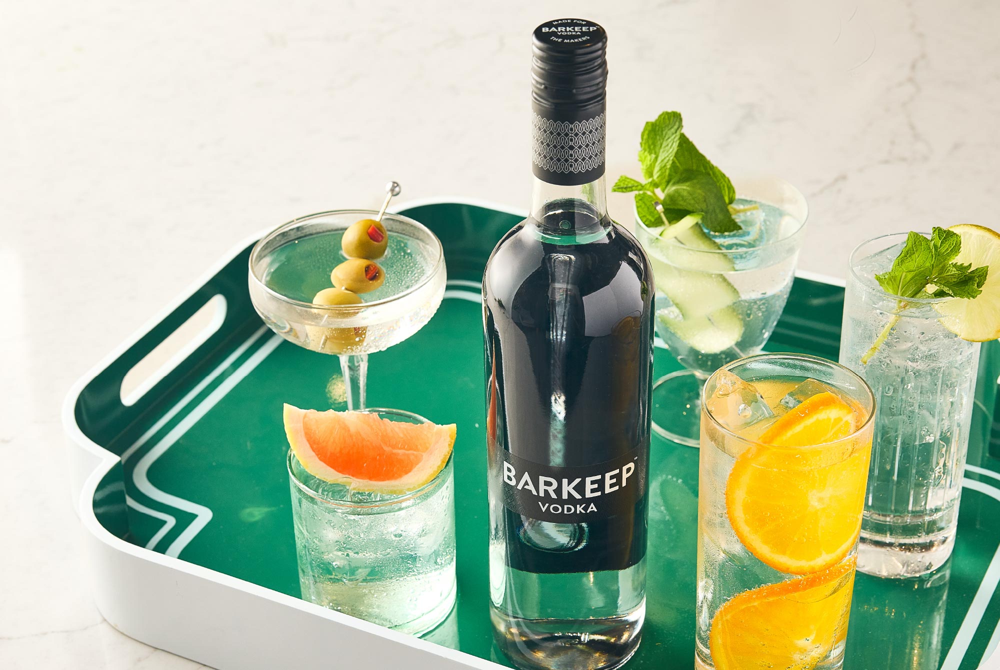 Barkeep Vodka bottle sitting on a colorful tray with clean, refreshing cocktails.